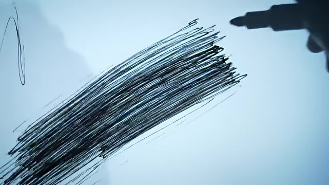 A drawing on a lit surface with parallel black scribbles drawn by a black stylus