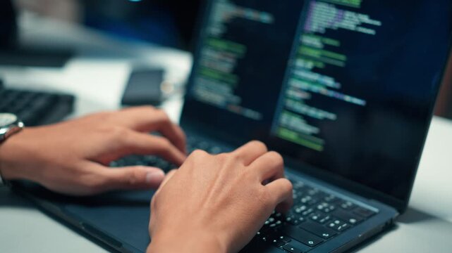 Developer typing program code focusing on cybersecurity and backend programming for secure systems.