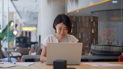 Middle-aged woman using computer technology for financial marketing work online. Busy mature Asian professional businesswoman analyst working concentrated on laptop pc at desk in office. Copy space - Powered by Adobe