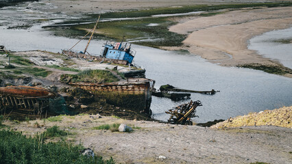 old abandoned sunken ship in the water at the ship cemetery
