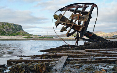 old abandoned sunken ship in the water at the ship cemetery