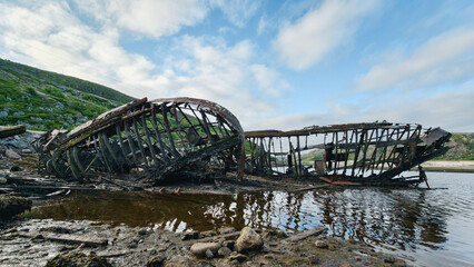 old abandoned sunken ship in the water at the ship cemetery