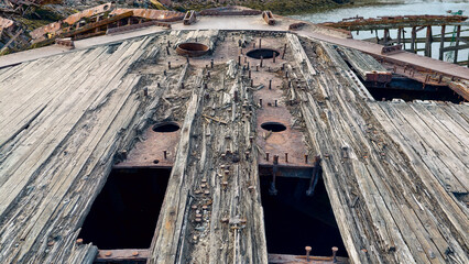 old abandoned sunken ship in the water at the ship cemetery wood pattern
