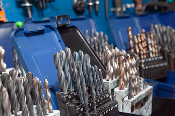 Sets of drills on a table in a workshop.