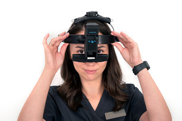 Ophthalmologist doctor with a forehead ophthalmoscope before performing a diagnostic procedure on his patient.