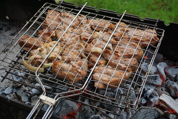 Juicy pork shish kebab sizzling on the grill over a barbecue in a country house, smoky barbecue with mouth-watering meat