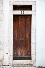 Weathered Wooden Door with Stone Frame and Number 82