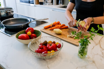 Woman Cooking Healthy Meatballs with Potatoes and Carrots in a Stylish Modern Kitchen