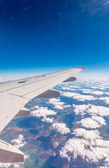 View from the airplane window at a beautiful cloudy sky and the airplane wing