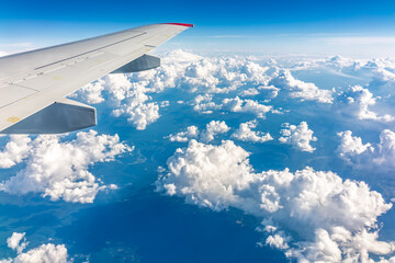 Obraz premium View from the airplane window at a beautiful cloudy sky and the airplane wing