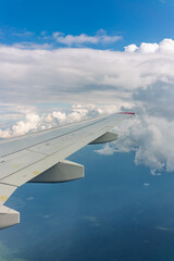 Obraz premium View from the airplane window at a beautiful cloudy sky and the airplane wing