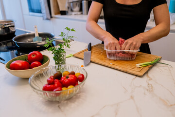 Woman Cooking Healthy Meatballs and Mashed Carrot Potatoes in a Stylish Modern Kitchen