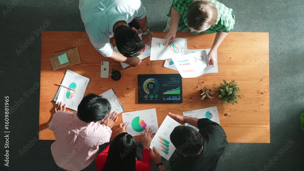 Wall mural top view of business people brainstorming and planning strategy by using financial graph or data ana