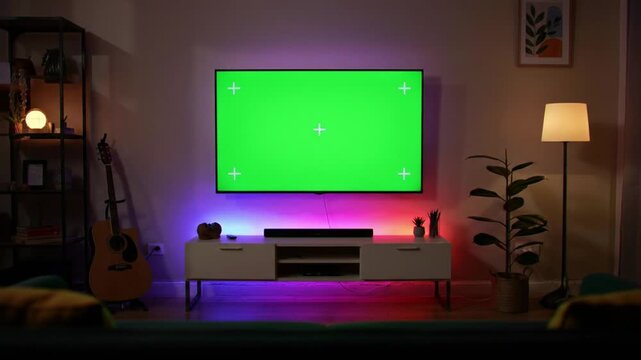 Wall-Mounted 4K Smart TV with Green Screen Display in Cozy Living Room | Ambient LED Backlight and Dim Lighting for Chroma Key Mockup