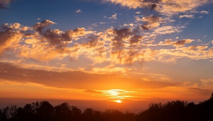 Fototapeta premium a bright and beautiful orange sky with clouds at dawn creates a heavenly backdrop for the sunrise