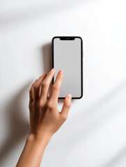 Hand reaching for smartphone with blank screen on white background