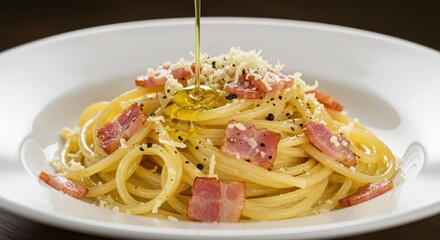 Close up of spaghetti carbonara on a white plate with olive oil being poured on the dish