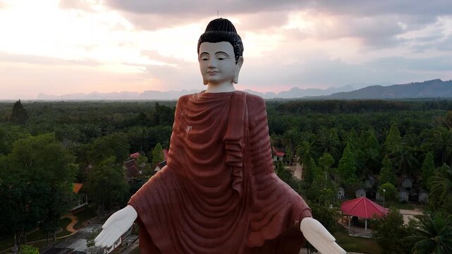 Majestic buddha statue in Wat Bang Thong temple, Krabi, Thailand, a peaceful landscape during a vibrant sunset. Popular religious site of krabi province.