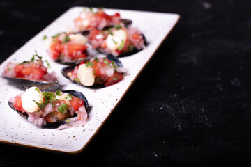 White tray with typical Peruvian appetizers called Choros a la chalaca.