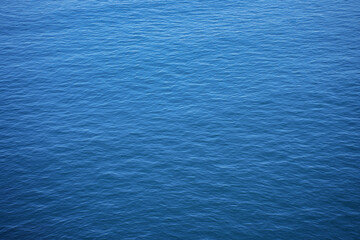 An abstract close-up of the deep blue sea surface, with gentle ripples and light creating a calming texture.