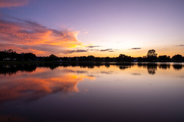 Vibrant Orange Sunset Over Calm Lake with Reflections