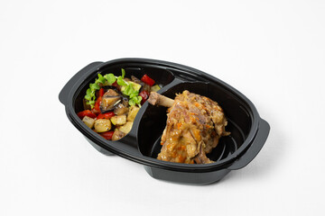 Stewed chicken in sauce with braised vegetables on a plate on white background