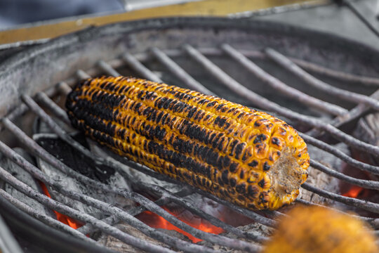 Popular Turkish street food, misir, freshly boiled sweet corn on the cob, roasted on a coal grill and sprinkled with salt and spices, Istanbul, Turkey