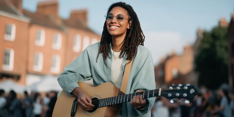 Young african female musician playing guitar outdoors at street festival
