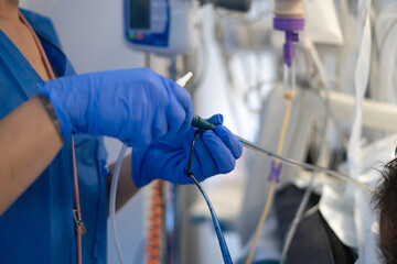 Nurse connecting medical tubes in hospital room getting patient ready for surgery