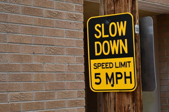 "Slow down speed limit 25" Sign on telephone pole.