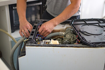The master repairs the dishwasher at home