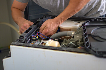 The master repairs the dishwasher at home