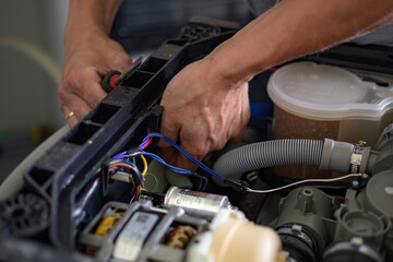 The master repairs the dishwasher at home
