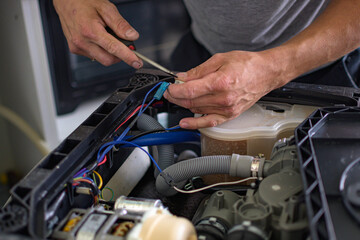 The master repairs the dishwasher at home