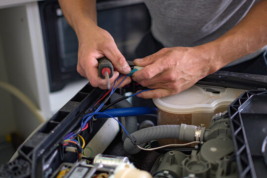 The master repairs the dishwasher at home - Powered by Adobe
