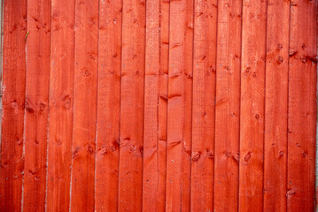 Rustic Red Wooden Fence with Vertical Planks and Aged Texture