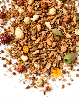 A scattered assortment of rant dried herbs and botanicals on a clean white background