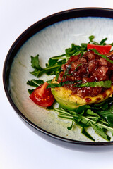 A Vibrant Dish Featuring Fresh Avocado and Hearty Toppings on a Bed of Greens, Garnished with Cherry Tomatoes for a Wholesome Culinary Delight