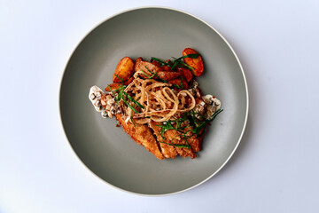 Crispy Fried Fish Plate with Garnishes and Sides, Showcasing a Delicious Culinary Presentation of Flavorful Accompaniments and Textural Elements