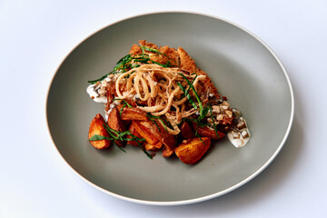 A Delicious Plate Featuring Crispy Chicken, Seasoned Potatoes, and Fresh Herbs, Elegantly Presented on a Modern Gray Dish