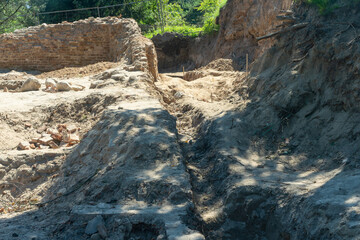 Obraz premium Historical Ruins Unearthed Archaeology Site. Urban Archaeological Excavation Showing Old Brick Wall Structure And Stratified Earth In Historical Research Project.