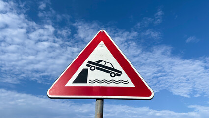 Road sign warning of the danger of falling into the water on an unprotected dock.