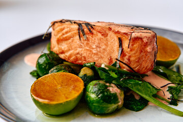 Deliciously Grilled Salmon Fillet Served with Fresh Brussels Sprouts and Slices of Lime Garnished with a Creamy Sauce for an Inviting Culinary Delight