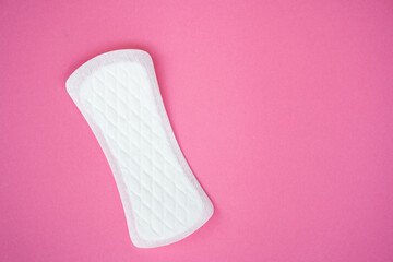 Single white sanitary pad isolated on a plain pink background. Suitable for topics related to feminine hygiene, menstruation, and personal care products.