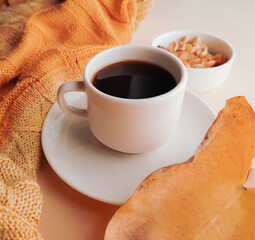 white cup of coffee on a light background in autumn colors
