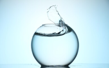 Glass aquarium with water on light blue background