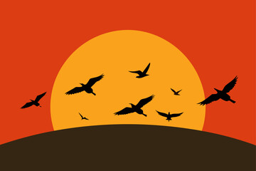 Obraz premium Silhouettes of birds flying against a vibrant sunset sky
