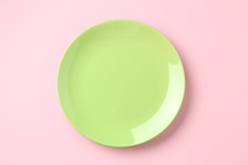 Stylish plate on pink background, top view