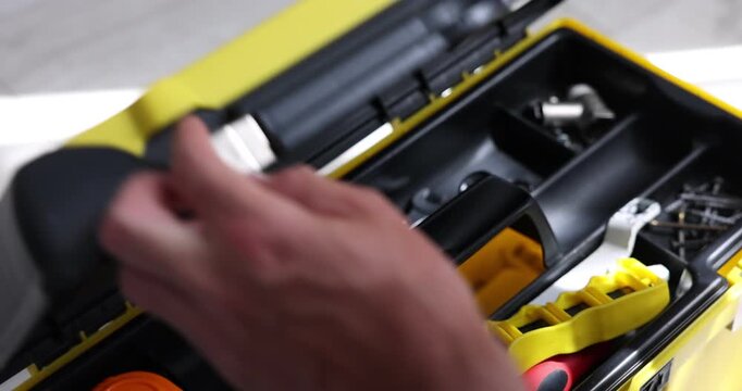 Man opening tool box and taking wrench indoors, closeup