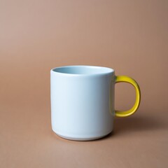 Obraz premium Minimalist White Ceramic Mug with Yellow Handle on Neutral Background Ideal for Mockups and Product Presentations showcasing modern design and simple aesthetic